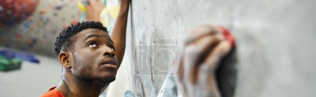 Téléchargez les photos : Sportif afro-américain modèle masculin escalade mur de blocs et levant les yeux, sportif, bannière - en image libre de droit