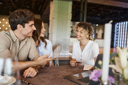 Téléchargez les photos : Homme souriant parlant au coordonnateur de banquet près petite amie heureuse dans la salle d'événement, préparation de la mariée - en image libre de droit