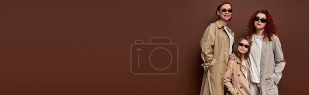 Téléchargez les photos : Générations féminines en lunettes de soleil et manteaux sur fond marron, mains dans les poches, bannière - en image libre de droit