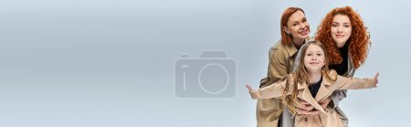 Photo for Female generations, women and child with red hair posing in autumnal coats on grey backdrop, banner - Royalty Free Image