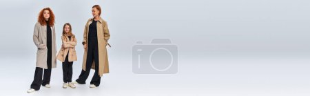 Photo for Redhead family in coats posing while standing on grey background, happy female generations, banner - Royalty Free Image