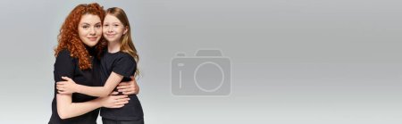 Téléchargez les photos : Concept deux générations, mère rousse heureuse et enfant en costume assorti étreignant sur gris, bannière - en image libre de droit