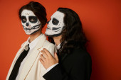 stylish couple in dia de los muertos makeup, spooky man hugging woman looking at camera on red magic mug #676492556