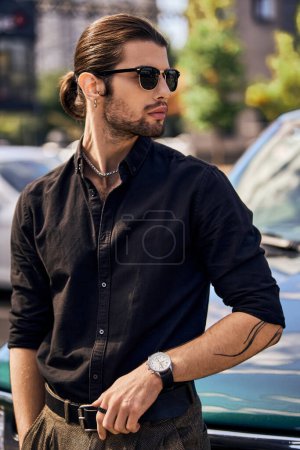 Photo for Vertical shot of sexy driver with tattoo and stylish accessories standing next to his car, fashion - Royalty Free Image