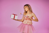 dreamy lovely woman in tooth fairy costume holding gift and magic wand posing on pink backdrop mug #676831766