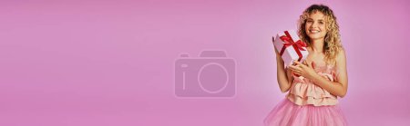 schöne hübsche Frau im rosafarbenen Kostüm der Zahnfee, die in die Kamera schaut und Geschenk hält, Banner