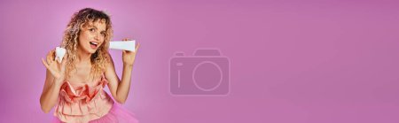 Photo for Joyful pretty tooth fairy in pink costume and headband with tooth paste and baby tooth, banner - Royalty Free Image