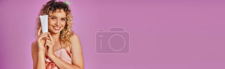 Photo for Joyous pretty woman in pink tooth fairy costume and headband holding tooth paste, banner - Royalty Free Image
