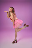 attractive woman in tooth fairy costume with face stickers standing on one leg and blowing kiss Poster #676832312