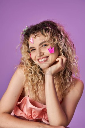 portrait of cheerful lovely woman in tooth fairy costume with face stickers looking at camera