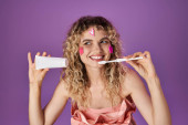 smiley blonde tooth fairy in pink costume with face stickers holding toothbrush and dental paste magic mug #676832482