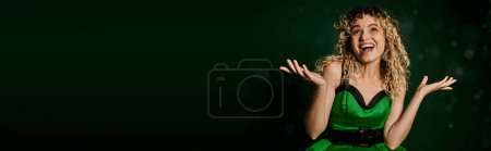 Téléchargez les photos : Femme heureuse habillée comme un elfe de nouvelle année attrapant les premiers flocons de neige sur fond vert foncé, bannière - en image libre de droit