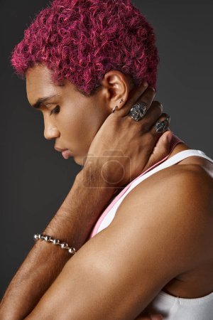 Porträt eines hübschen Mannes mit rosa Haaren, der im Profil posiert und Accessoires, Mode und Stil trägt