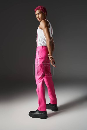 guapo afroamericano modelo masculino posando con las manos detrás mirando cámara, moda y estilo