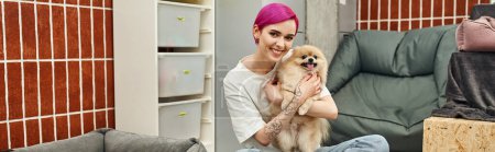 fröhlicher Hundesitter umarmt Pommernspitz und blickt in Haustierhotel in die Kamera, liebevolle Pflege, Banner