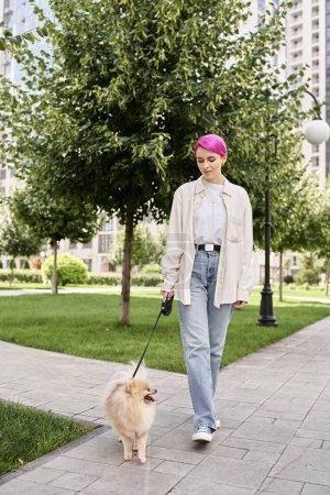 full length of stylish purple-haired woman walking with pomeranian spitz on automated leash