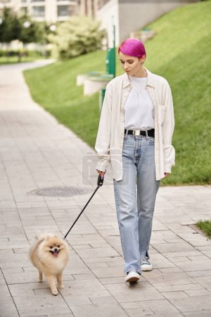 woman with purple hair walking in city with cute pomeranian spitz on roulette leash, urban life
