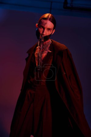 Téléchargez les photos : Plan vertical de beau sexy homme en élégant masque futuriste posant et regardant la caméra - en image libre de droit