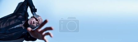 Téléchargez les photos : Séduisant jeune homme en chemise élégante posant avec la main devant la caméra, concept de mode, bannière - en image libre de droit