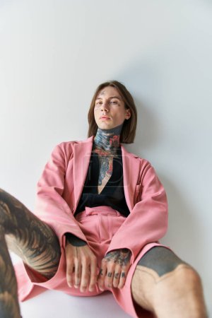 vertical shot of stylish young man in pink blazer and shorts looking at camera, fashion concept