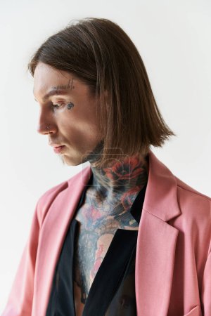Téléchargez les photos : Plan vertical de bel homme avec des tatouages élégants et perçant détournant les yeux, concept de mode - en image libre de droit