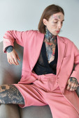 stylish alluring man with tattoos in pink blazer and shorts sitting on chair, fashion concept Longsleeve T-shirt #679134278
