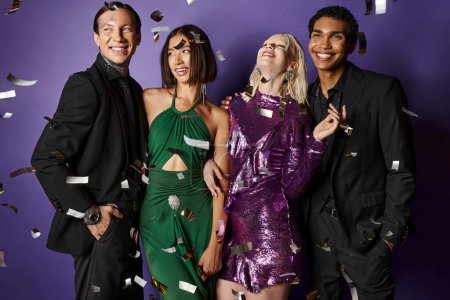Nouvel An 2024, amis interracial en vêtements de fête souriant près de confettis tombant sur fond violet