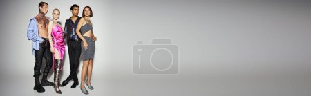 Téléchargez les photos : Modèles multiethniques élégants en tenue de fête posant sur fond gris, 2024 bannière Nouvel An - en image libre de droit