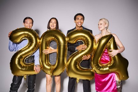 group of happy multiethnic friends holding balloons with 2024 numbers during party, New Year concept