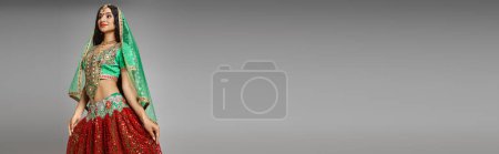 Téléchargez les photos : Belle jeune femme indienne en costume traditionnel avec accessoires sur fond gris, bannière - en image libre de droit