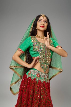 Téléchargez les photos : Plan vertical de belle femme indienne aux cheveux longs avec bindi dot gestuelle et détournant les yeux - en image libre de droit