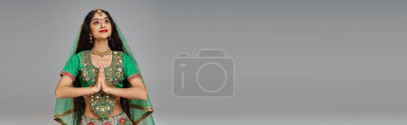 Téléchargez les photos : Belle femme indienne en costume national avec accessoires priant et détournant les yeux, bannière - en image libre de droit