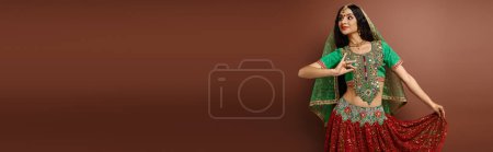 Photo for Beautiful indian woman with bindi dot in traditional attire gesturing while dancing lively, banner - Royalty Free Image