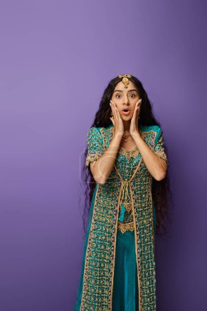 Photo for Vertical shot of amazed indian woman in blue sari with hands near face looking shockingly at camera - Royalty Free Image