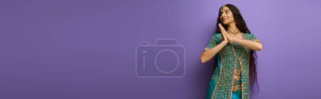 Photo for Cheerful indian woman in blue sari with accessories posing in motion on purple backdrop, banner - Royalty Free Image