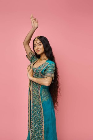 Photo for Beautiful indian woman in blue sari with accessories gesturing on pink backdrop looking at camera - Royalty Free Image