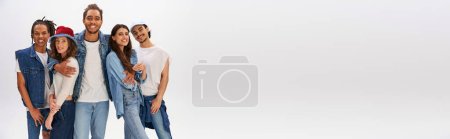 Photo for Happy african american man smiling at camera near stylish multicultural friends  on grey, banner - Royalty Free Image