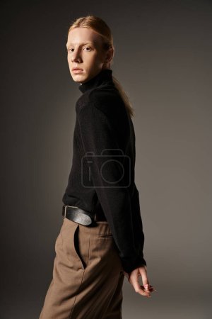 good looking young non binary model in black turtleneck turning head and looking at camera, fashion