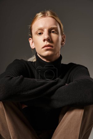 portrait of young n on binary person in stylish black turtleneck with red hair looking at camera