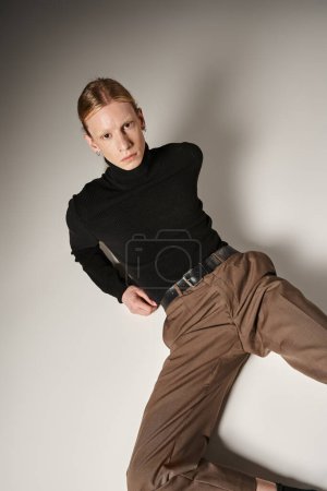 Photo for Vertical shot of attractive non binary person with ponytail lying on floor looking at camera - Royalty Free Image