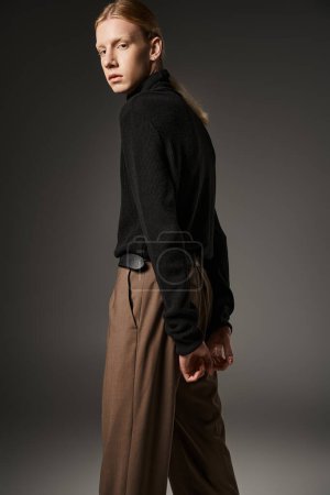 Photo for Handsome non binary model with red hair and ponytail posing with hands behind back, fashion concept - Royalty Free Image
