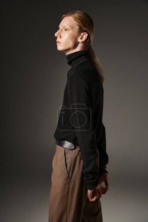 Photo for Attractive non binary person in trendy black turtleneck posing in profile with hands behind back - Royalty Free Image