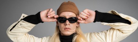 Photo for Appealing stylish non binary model in warm attire touching sunglasses, fashion concept, banner - Royalty Free Image