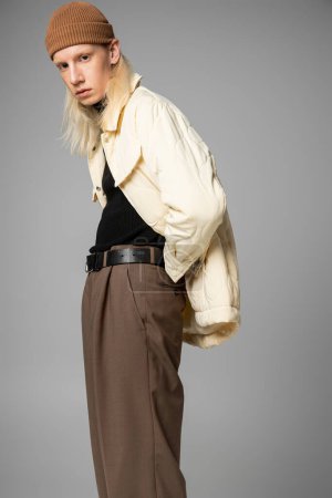 attractive young non binary person with long hair posing and looking at camera, fashion concept