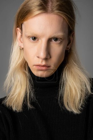 Photo for Vertical shot of good looking young non binary person in black turtleneck posing on gray backdrop - Royalty Free Image