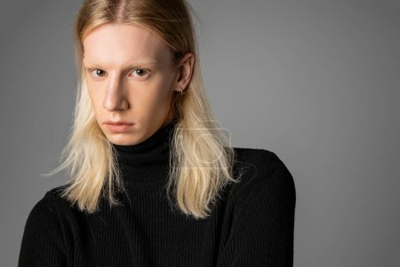 Photo for Young handsome non binary person in stylish warm black turtleneck looking at camera, fashion - Royalty Free Image