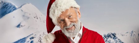 cheerful white bearded Santa smiling at camera with snowy mountain backdrop, winter concept, banner