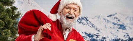 jolly white bearded Santa with gift bag smiling cheerfully at camera, winter concept, banner
