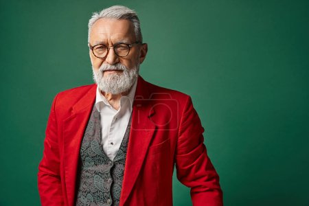 stylish classy man dressed as Santa with glasses and beard looking at camera, winter concept