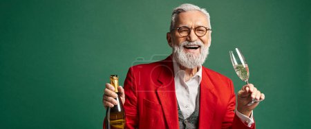 Téléchargez les photos : Chic Père Noël joyeux appréciant le champagne et souriant à la caméra, concept d'hiver, bannière - en image libre de droit